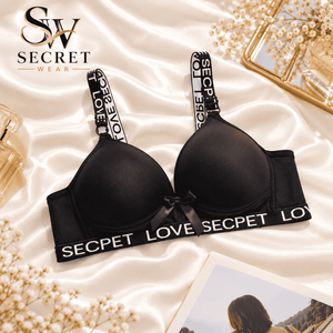 Love Secret Padded Bra in black, with smooth padded cups, white printed straps and LOVE-lettered band, and a small bow detail.